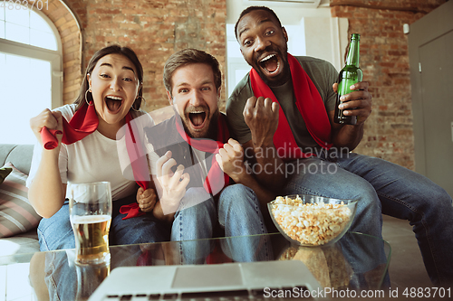 Image of Excited football fans watching sport match at home, remote support of favourite team during coronavirus pandemic outbreak