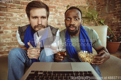 Image of Excited football fans watching sport match at home, remote support of favourite team during coronavirus pandemic outbreak