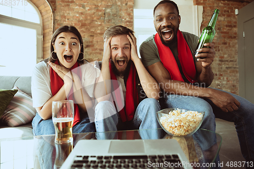 Image of Excited football fans watching sport match at home, remote support of favourite team during coronavirus pandemic outbreak