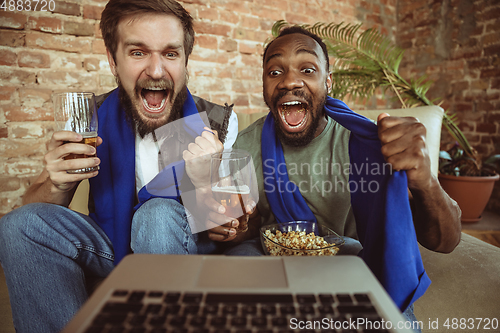 Image of Excited football fans watching sport match at home, remote support of favourite team during coronavirus pandemic outbreak