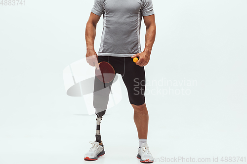 Image of Athlete with disabilities or amputee isolated on white studio background. Professional male table tennis player with leg prosthesis training and practicing in studio.