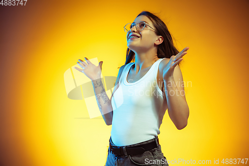 Image of Portrait of young caucasian woman isolated on gradient yellow studio background