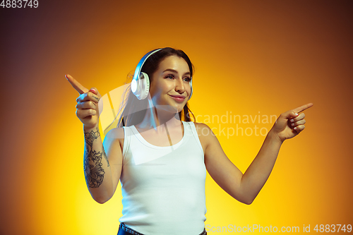 Image of Portrait of young caucasian woman isolated on gradient yellow studio background