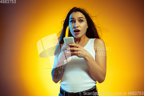 Image of Portrait of young caucasian woman isolated on gradient yellow studio background