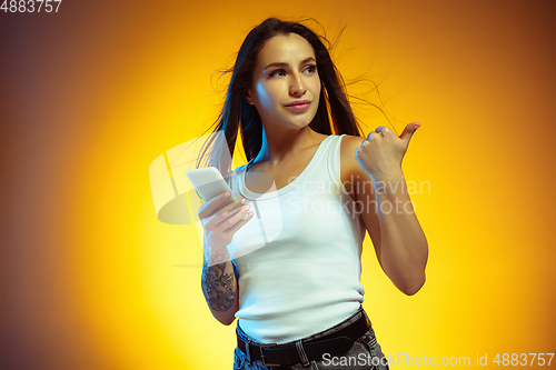 Image of Portrait of young caucasian woman isolated on gradient yellow studio background