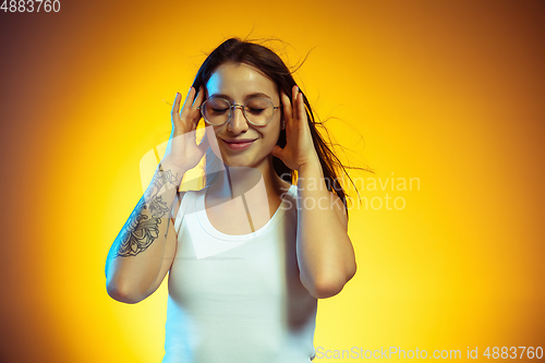 Image of Portrait of young caucasian woman isolated on gradient yellow studio background