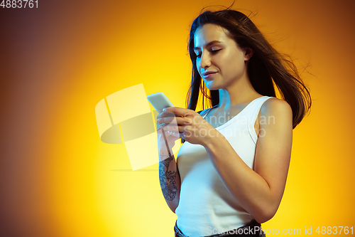 Image of Portrait of young caucasian woman isolated on gradient yellow studio background