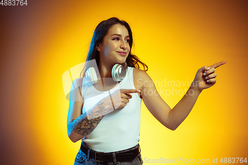 Image of Portrait of young caucasian woman isolated on gradient yellow studio background