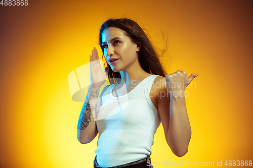 Image of Portrait of young caucasian woman isolated on gradient yellow studio background