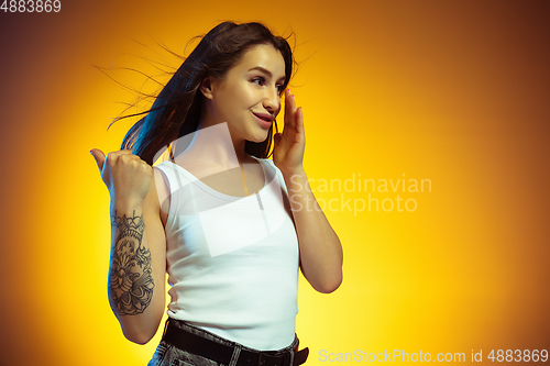 Image of Portrait of young caucasian woman isolated on gradient yellow studio background