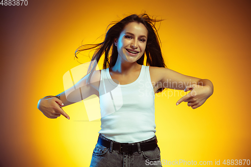 Image of Portrait of young caucasian woman isolated on gradient yellow studio background