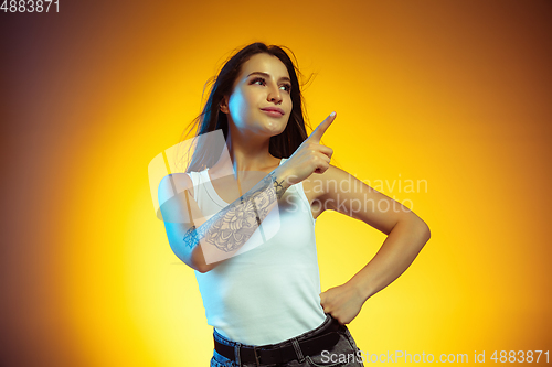 Image of Portrait of young caucasian woman isolated on gradient yellow studio background