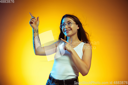 Image of Portrait of young caucasian woman isolated on gradient yellow studio background