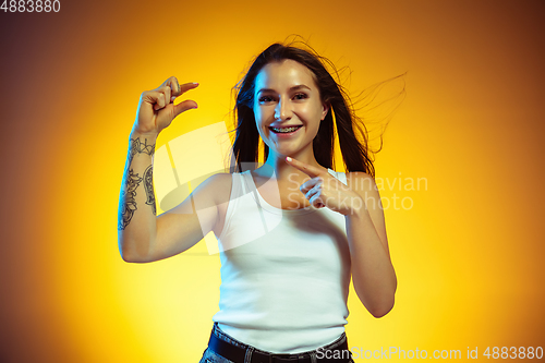 Image of Portrait of young caucasian woman isolated on gradient yellow studio background