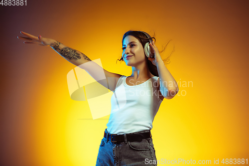 Image of Portrait of young caucasian woman isolated on gradient yellow studio background