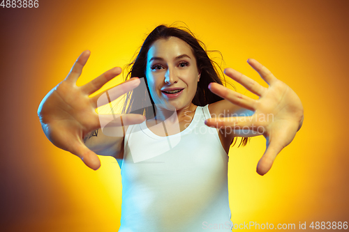 Image of Portrait of young caucasian woman isolated on gradient yellow studio background