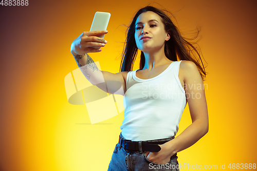 Image of Portrait of young caucasian woman isolated on gradient yellow studio background