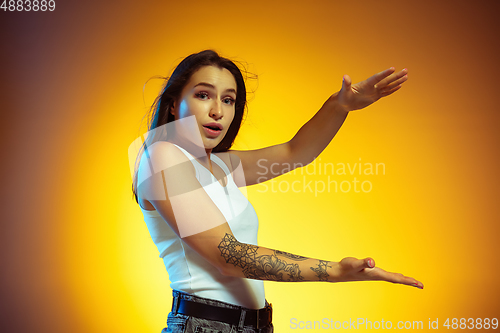 Image of Portrait of young caucasian woman isolated on gradient yellow studio background