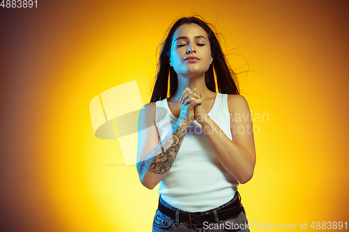 Image of Portrait of young caucasian woman isolated on gradient yellow studio background