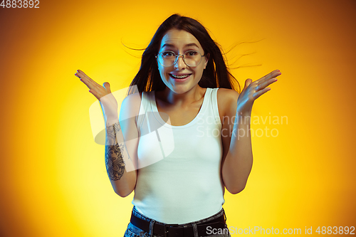 Image of Portrait of young caucasian woman isolated on gradient yellow studio background