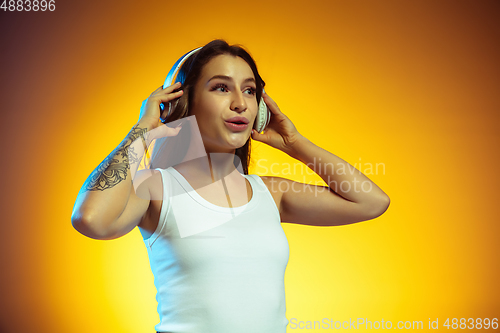 Image of Portrait of young caucasian woman isolated on gradient yellow studio background