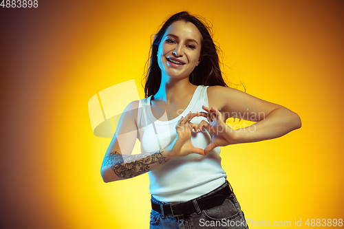 Image of Portrait of young caucasian woman isolated on gradient yellow studio background