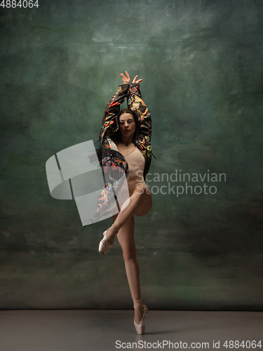 Image of Young graceful tender ballerina on dark green studio background