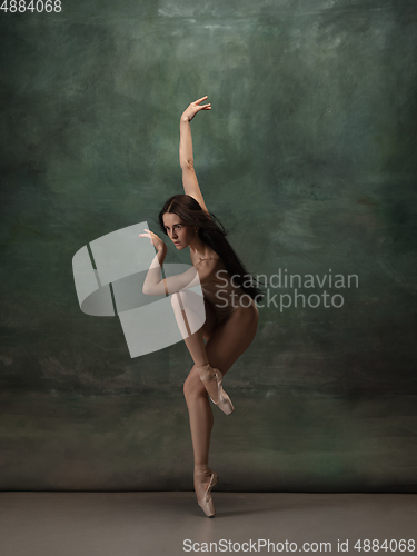 Image of Young graceful tender ballerina on dark green studio background