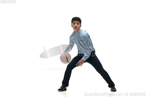 Image of Man in office clothes playing basketball on white background. Unusual look for businessman in motion, action. Sport, healthy lifestyle.