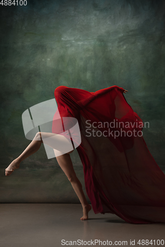 Image of Young graceful tender ballerina on dark green studio background