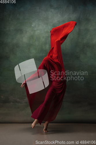 Image of Young graceful tender ballerina on dark green studio background