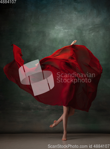 Image of Young graceful tender ballerina on dark green studio background