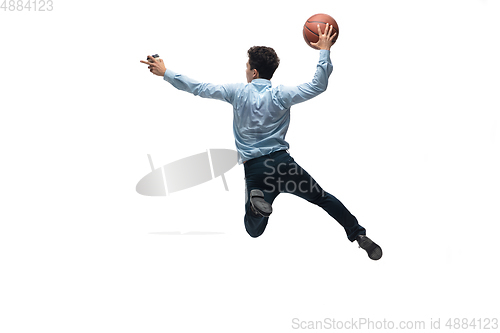 Image of Man in office clothes playing basketball on white background. Unusual look for businessman in motion, action. Sport, healthy lifestyle.