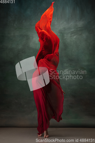 Image of Young graceful tender ballerina on dark green studio background