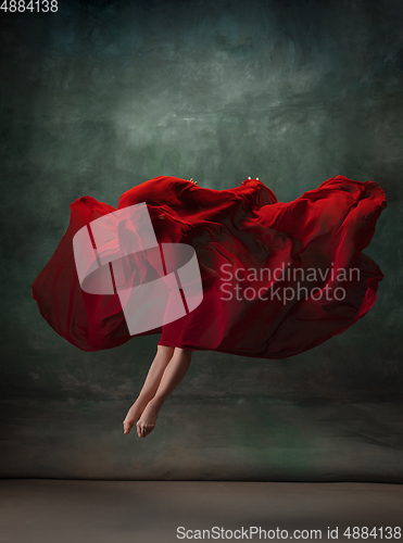 Image of Young graceful tender ballerina on dark green studio background