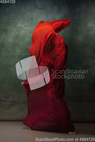 Image of Young graceful tender ballerina on dark green studio background