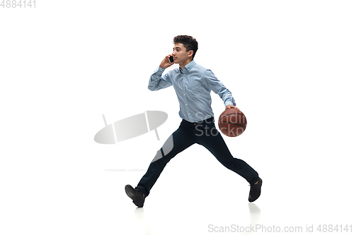 Image of Man in office clothes playing basketball on white background. Unusual look for businessman in motion, action. Sport, healthy lifestyle.