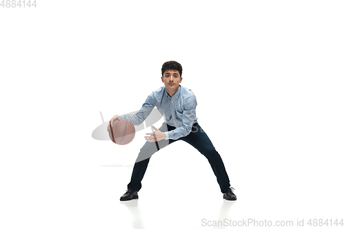 Image of Man in office clothes playing basketball on white background. Unusual look for businessman in motion, action. Sport, healthy lifestyle.