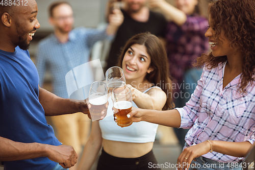 Image of Group of happy friends having beer party in summer day. Resting together outdoor, celebrating and relaxing, laughting. Summer lifestyle, friendship concept.
