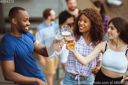 Image of Group of happy friends having beer party in summer day. Resting together outdoor, celebrating and relaxing, laughting. Summer lifestyle, friendship concept.