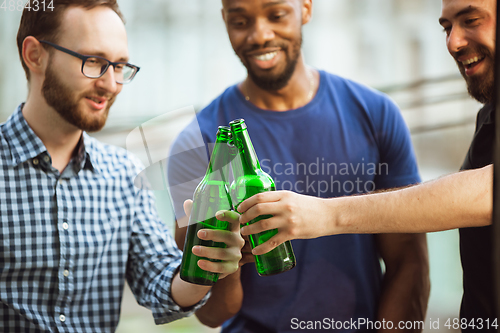 Image of Group of happy friends having beer party in summer day. Resting together outdoor, celebrating and relaxing, laughting. Summer lifestyle, friendship concept.