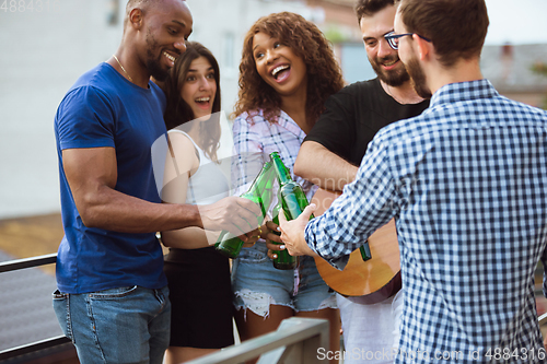 Image of Group of happy friends having beer party in summer day. Resting together outdoor, celebrating and relaxing, laughting. Summer lifestyle, friendship concept.