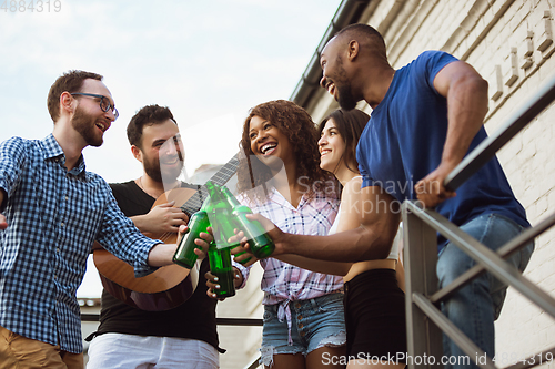 Image of Group of happy friends having beer party in summer day. Resting together outdoor, celebrating and relaxing, laughting. Summer lifestyle, friendship concept.