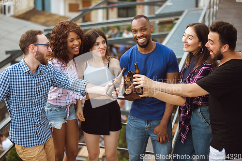 Image of Group of happy friends having beer party in summer day. Resting together outdoor, celebrating and relaxing, laughting. Summer lifestyle, friendship concept.