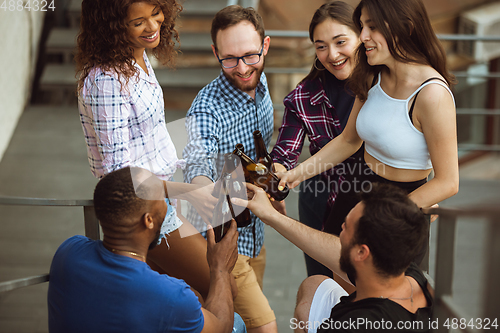 Image of Group of happy friends having beer party in summer day. Resting together outdoor, celebrating and relaxing, laughting. Summer lifestyle, friendship concept.