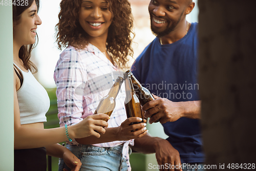 Image of Group of happy friends having beer party in summer day. Resting together outdoor, celebrating and relaxing, laughting. Summer lifestyle, friendship concept.