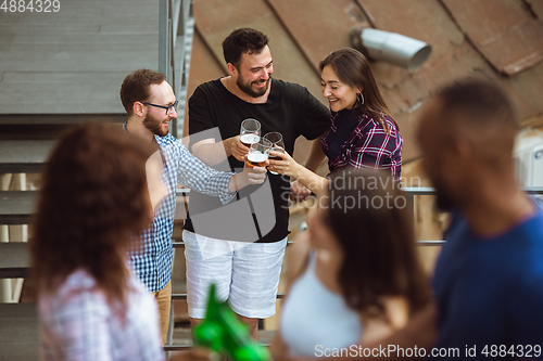Image of Group of happy friends having beer party in summer day. Resting together outdoor, celebrating and relaxing, laughting. Summer lifestyle, friendship concept.