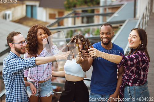 Image of Group of happy friends having beer party in summer day. Resting together outdoor, celebrating and relaxing, laughting. Summer lifestyle, friendship concept.