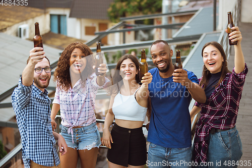 Image of Group of happy friends having beer party in summer day. Resting together outdoor, celebrating and relaxing, laughting. Summer lifestyle, friendship concept.