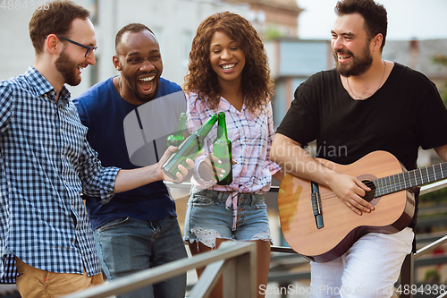 Image of Group of happy friends having beer party in summer day. Resting together outdoor, celebrating and relaxing, laughting. Summer lifestyle, friendship concept.